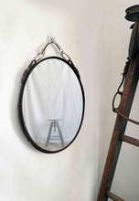 Load image into Gallery viewer, 12&quot;x16&quot; oval equestrian leather mirror with harness detail hanging on wall.