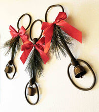 Load image into Gallery viewer, Holiday rustic iron equestrian bit door greeter with red satin bow and evergreen sprig.