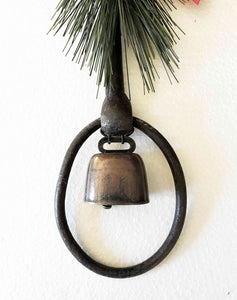 Holiday decor rustic iron equestrian bit door greeter with evergreen, red satin bow, and bronze mini cow bell.