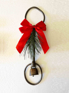 Holiday rustic iron equestrian bit door greeter with red satin bow and bronze bell.